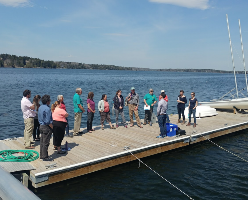 A group of scientists and volunteeres gathered on a dock for Shell Day last year