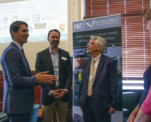 Rep. Dylan Fernandes, Matthew Charette and Michael Triantafyllou talk after a presentation on the Blue Economy at the State House