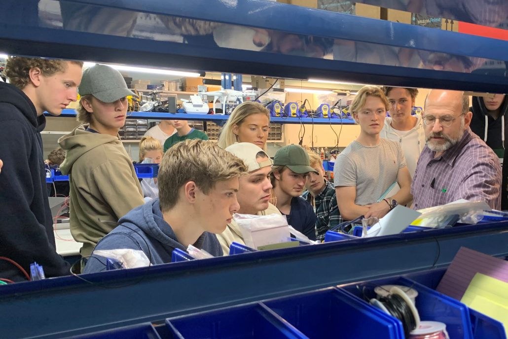 A group of students in a makerspace workshop listening to an instructor