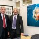 Senator Whitehouse meets and Keith Ellenbogen stand next to a large image of a jellyfish floating in blue water.