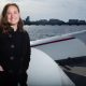 Michelle Kornberg at the MIT Sailing Pavilion dock on the Charles River with a row of sailboats behind