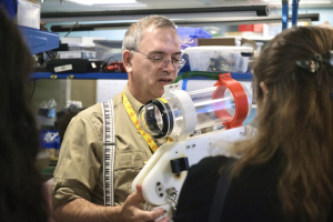 MIT Sea Grant Education Administrator Drew Bennett holds coastal monitoring robot